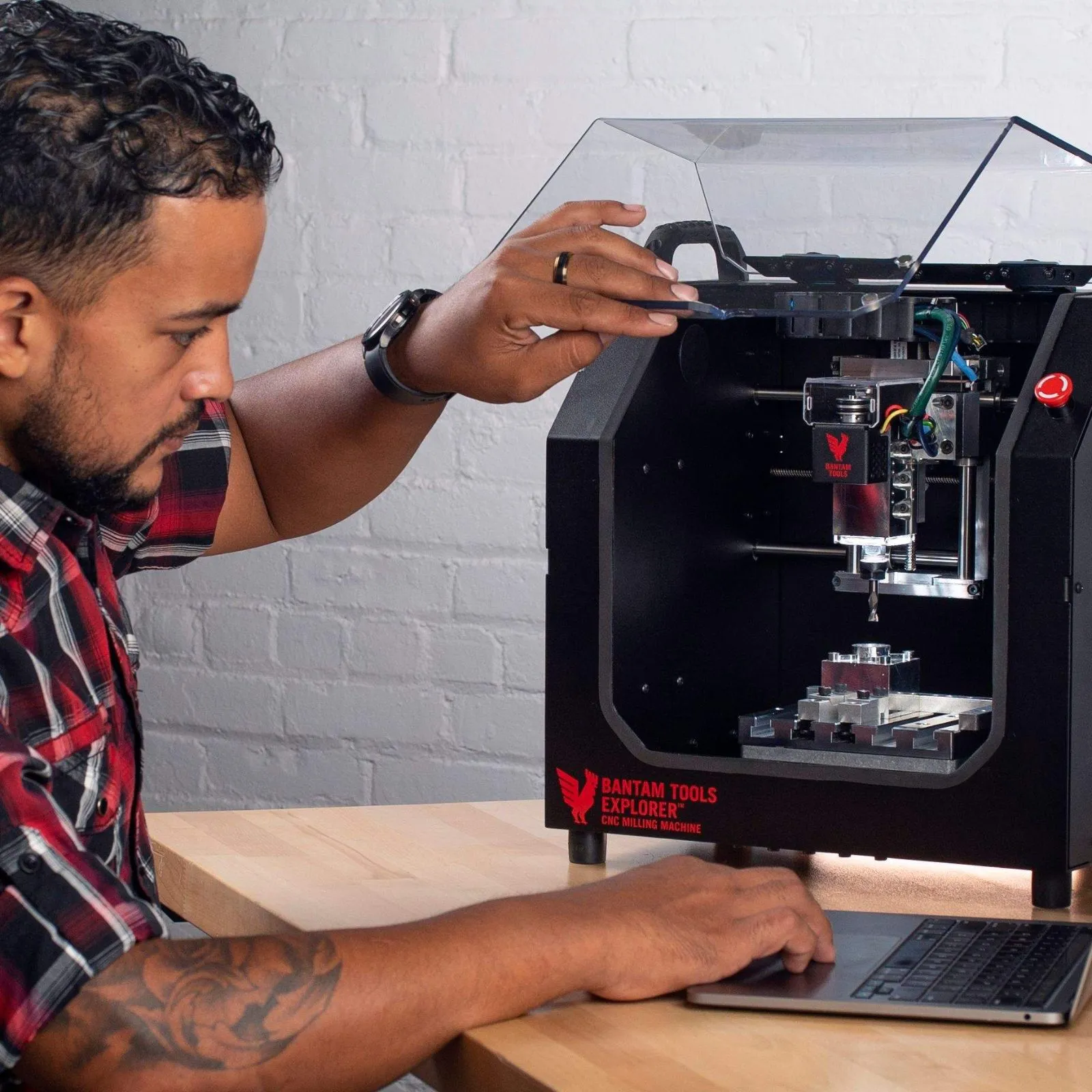 Man working at a Bantam Tools desktop CNC machine